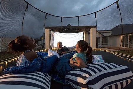A fun way to spend a summer night is by having a sleepover on your trampoline! Make sure to cover the top of the trampoline with a bedsheet, shade cover, or tarp to create a comfortable and safe space for you and your friends.